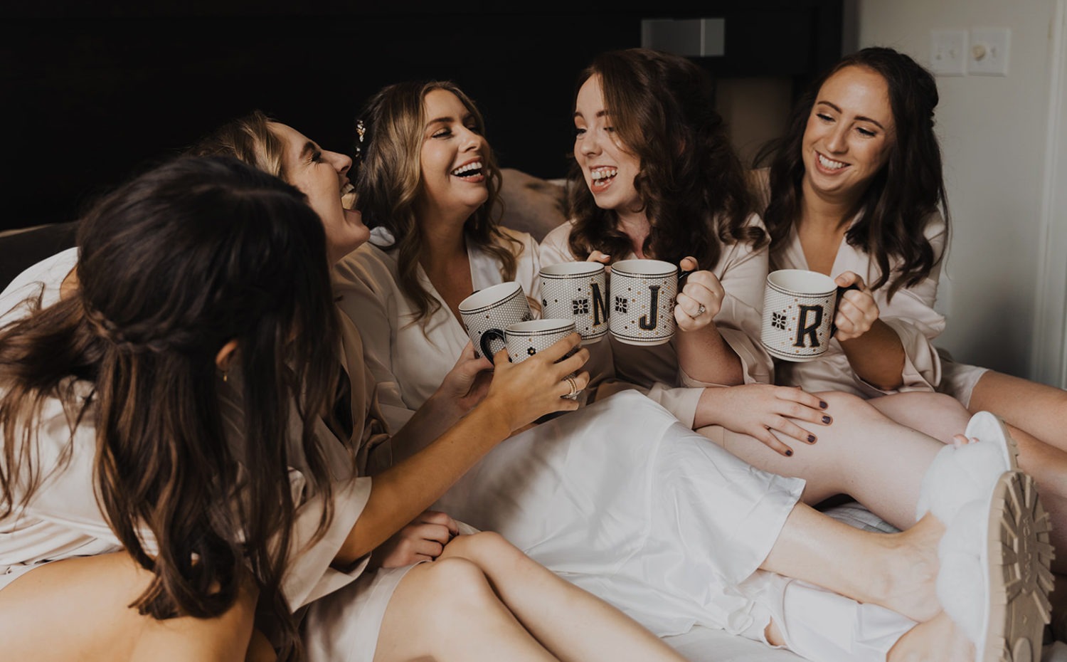 Bridesmaid cheers with mugs while getting ready at Virginia wedding venue