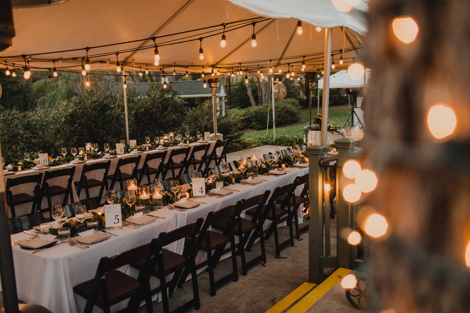 Greenery and candles decorate wedding reception tables