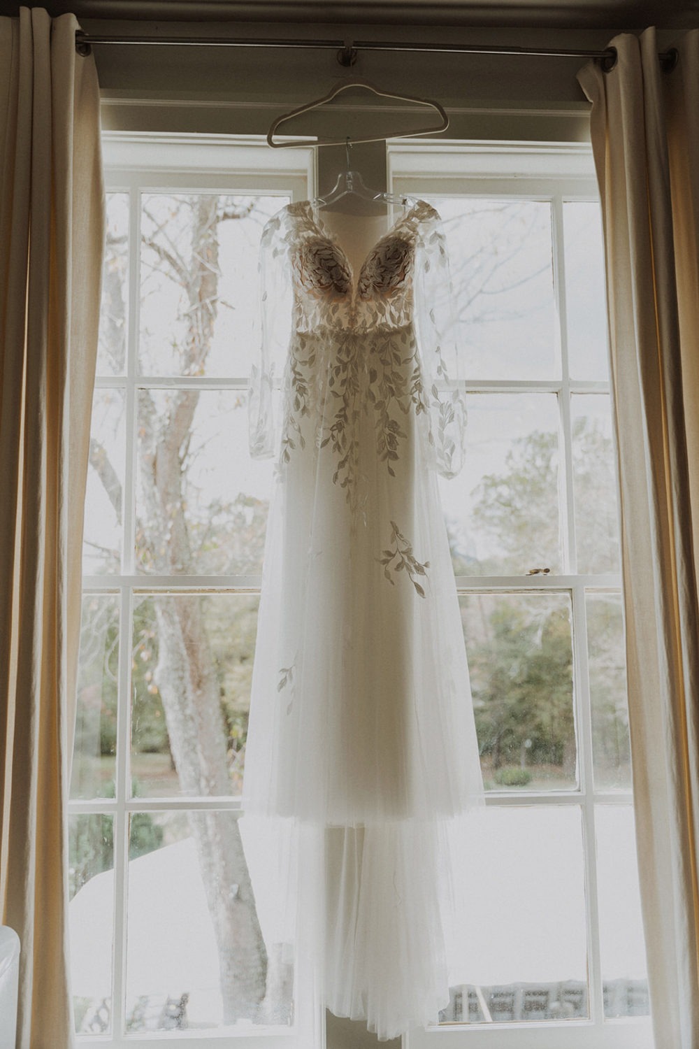 Wedding dress hangs on window at Virginia wedding venue