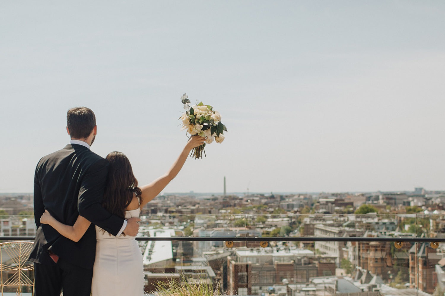 Couple looks at cityscape at DC rooftop elopement 