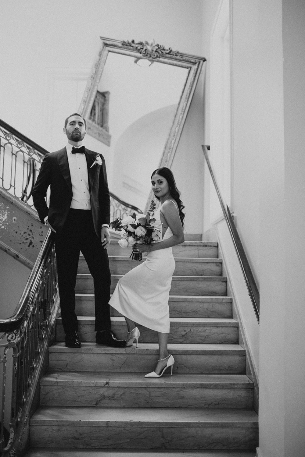 Couple stand on staircase holding wedding bouquet at the LINE DC hotel