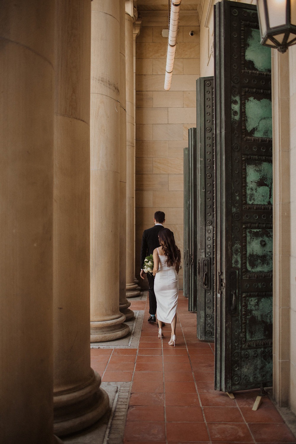 Couple walks in front of pillars at the LINE DC hotel