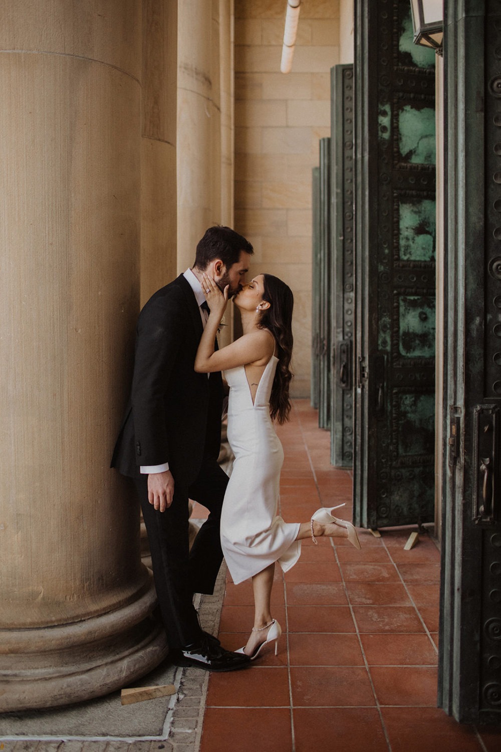 Couple kisses in front of pillars at the LINE DC hotel