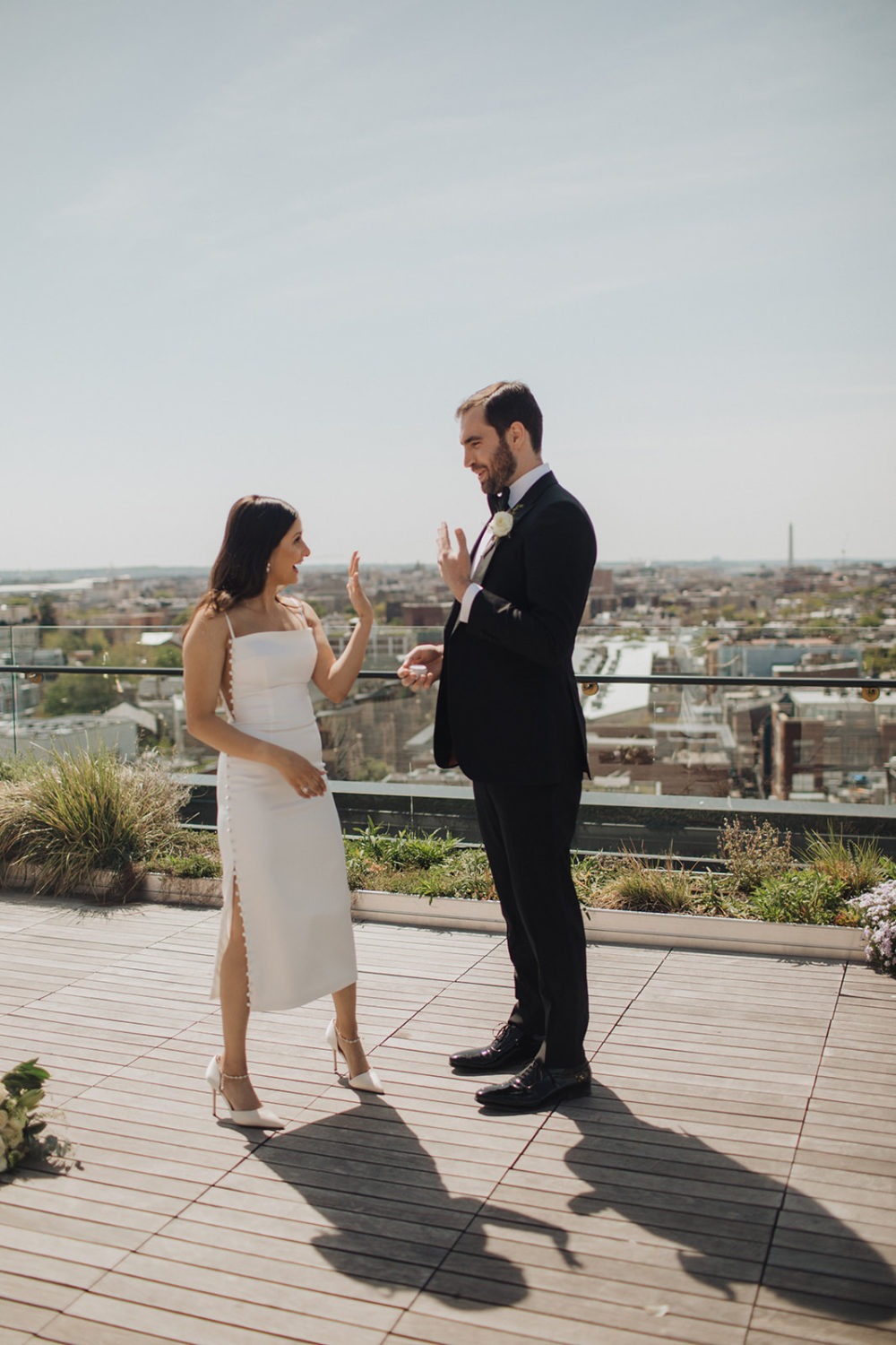 Couple holds up hands with wedding bands at DC rooftop elopement
