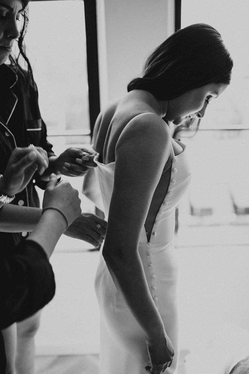 Bridesmaids helps bride zip up dress at DC hotel elopement