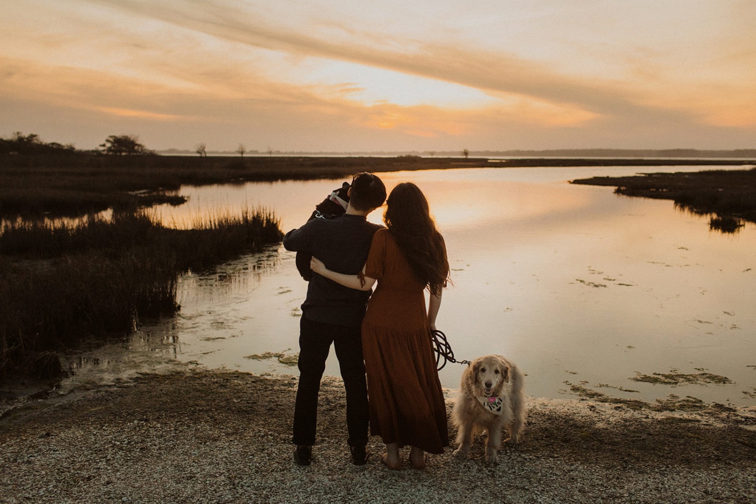 Couple holds dogs at Assateague Island sunset engagement session