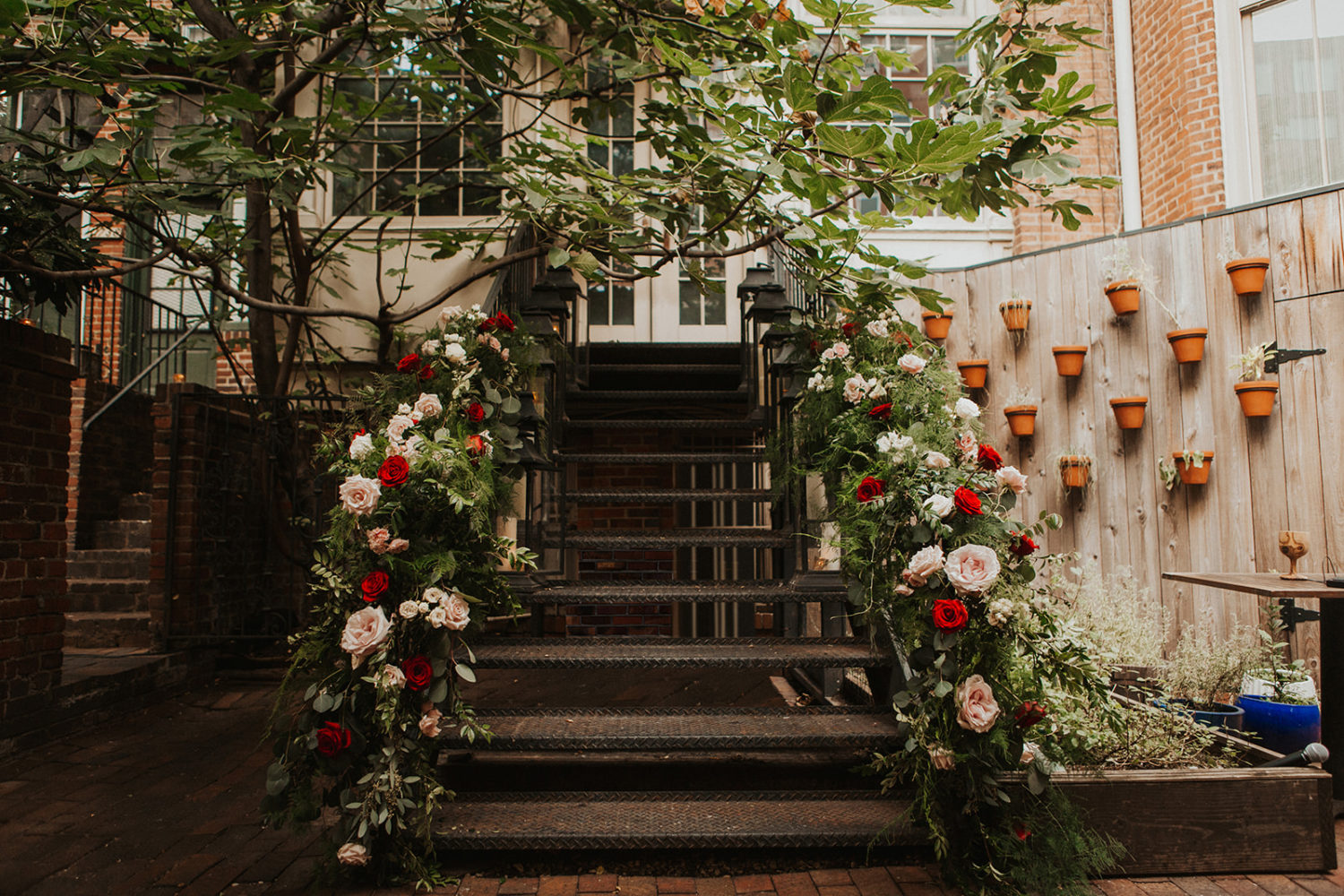 Pink and Red roses decorate railing at Iron Gate Restaurant DC wedding
