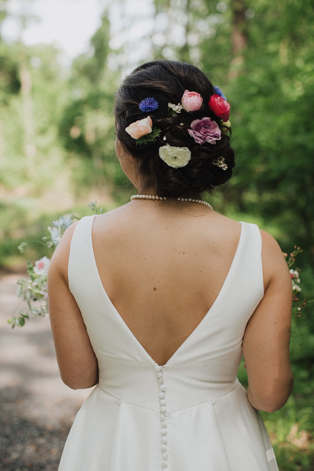 Bride has wildflowers in wedding hair updo
