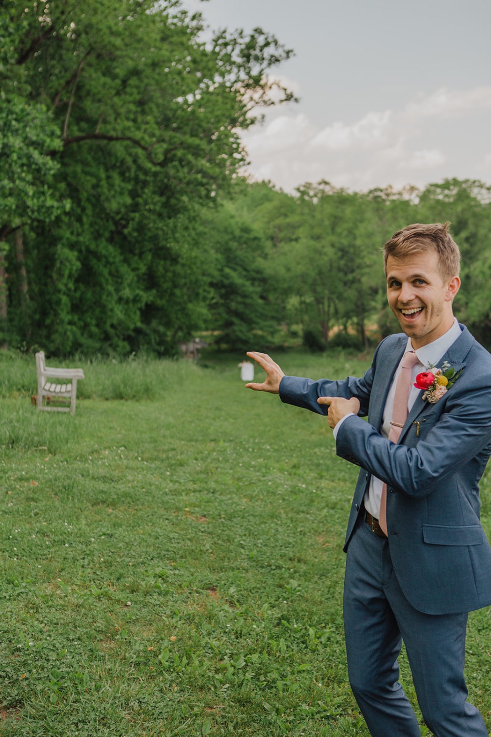 Groom stands on top of hill for first look at nature wedding venue