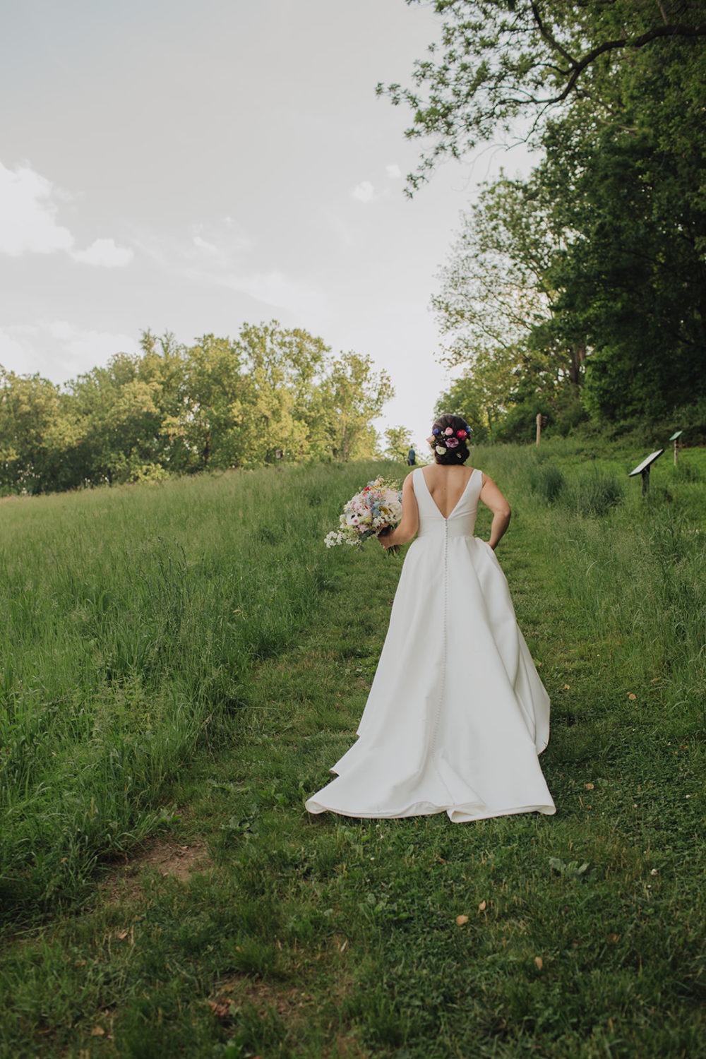 Bride walks up hill for first look at nature wedding venue