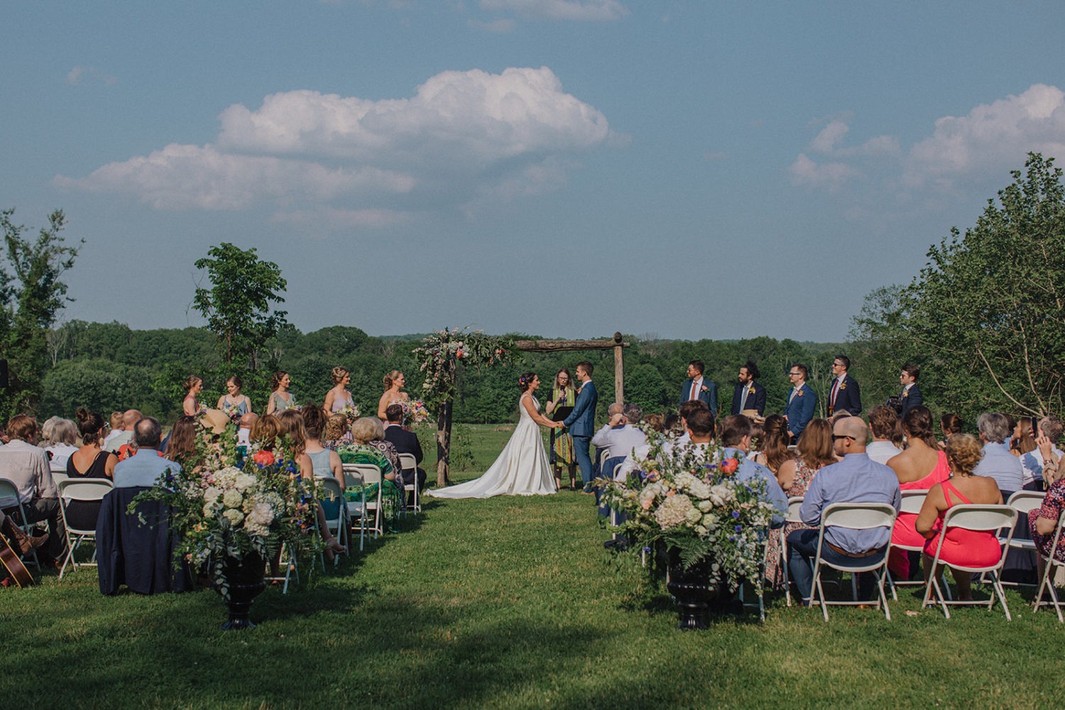 Couple exchanges vows during outdoor floral wedding ceremony