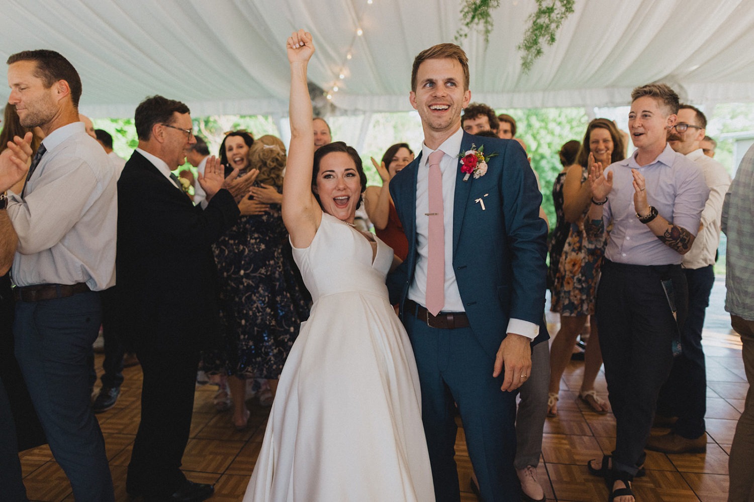 Couple cheers on the dance floor with guests at nature wedding venue