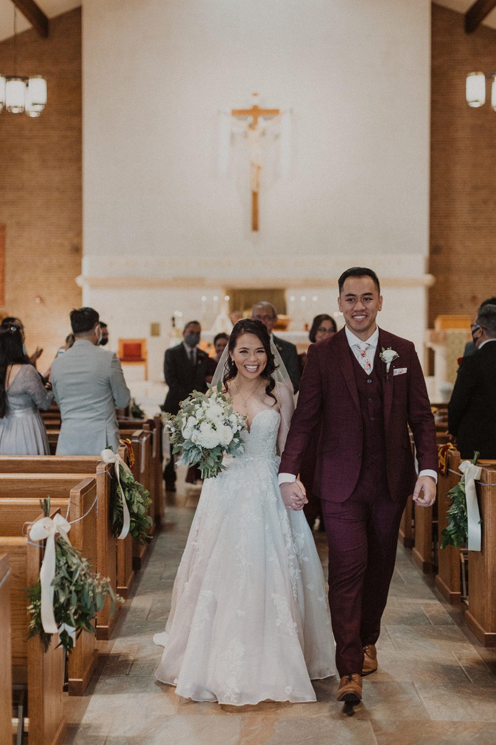 Couple exits holding hands at church wedding ceremony