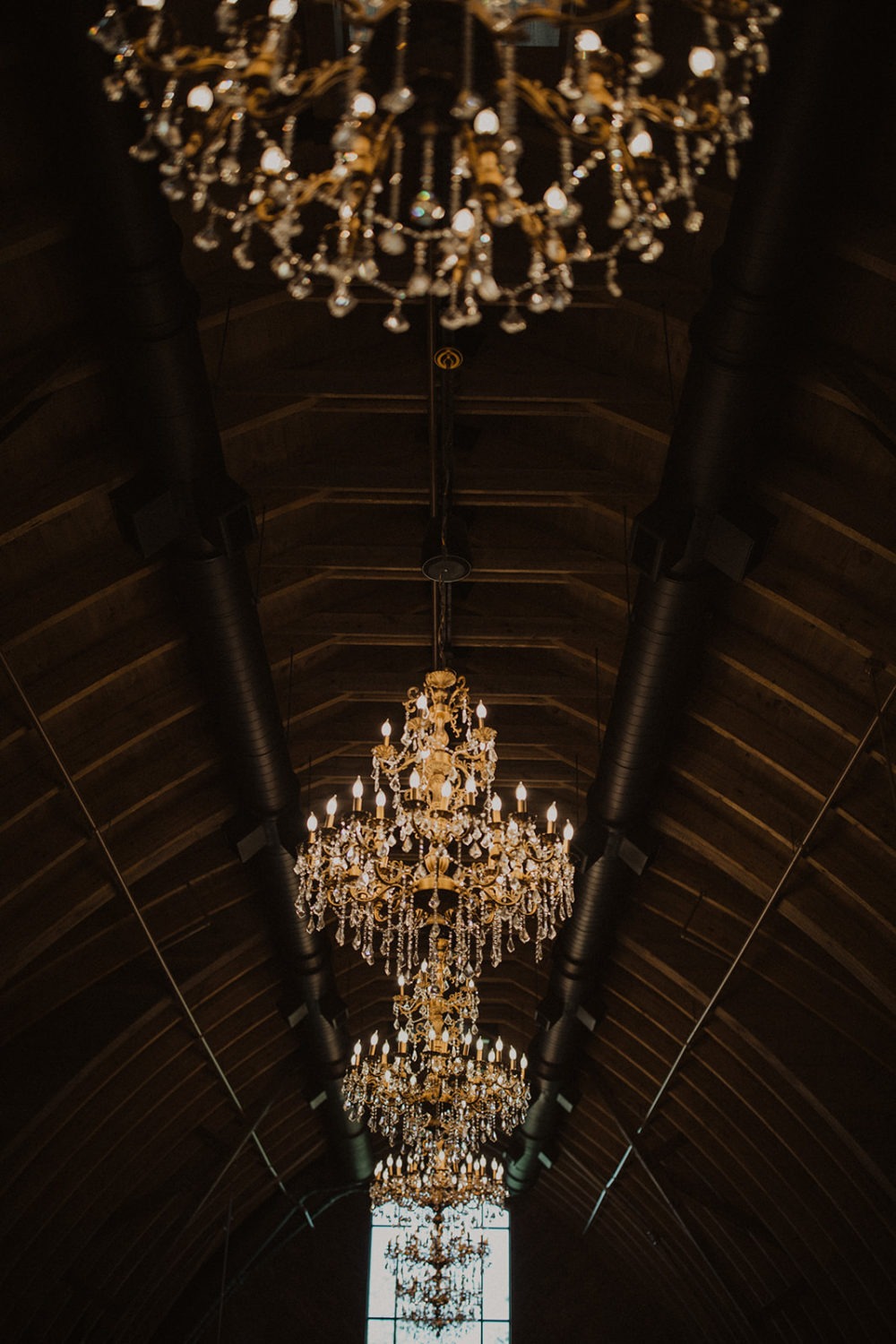 Lit chandeliers hang at Virginia barn wedding venue