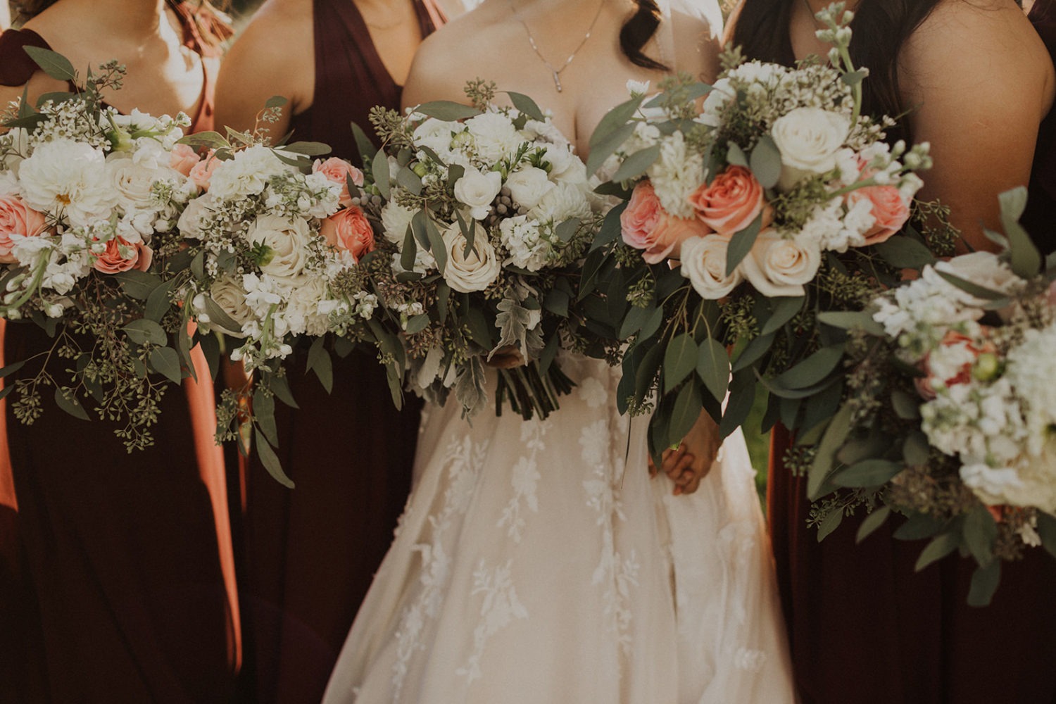 Bridesmaids surround bride holding wedding bouquets