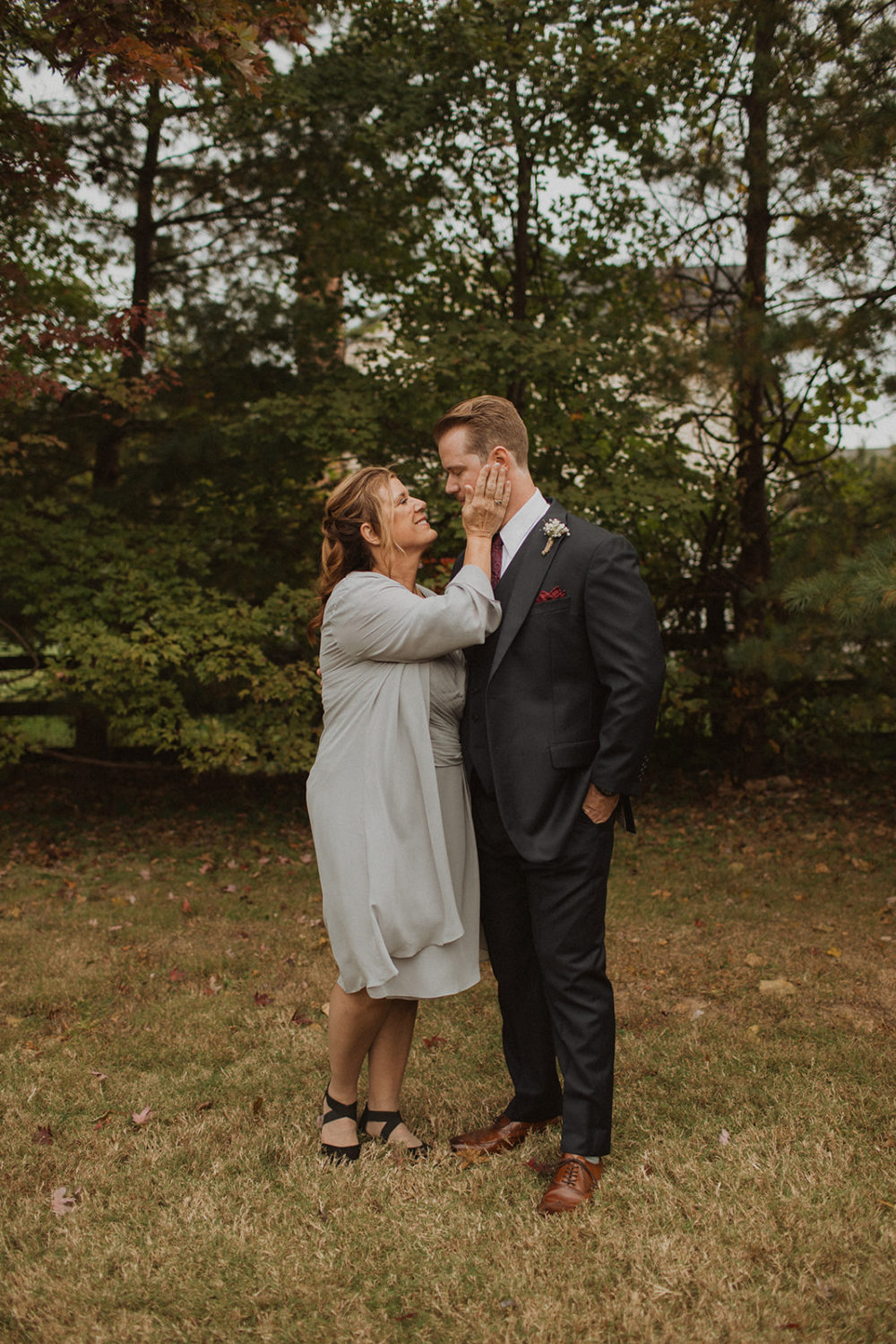 Mom embraces groom during family portraits