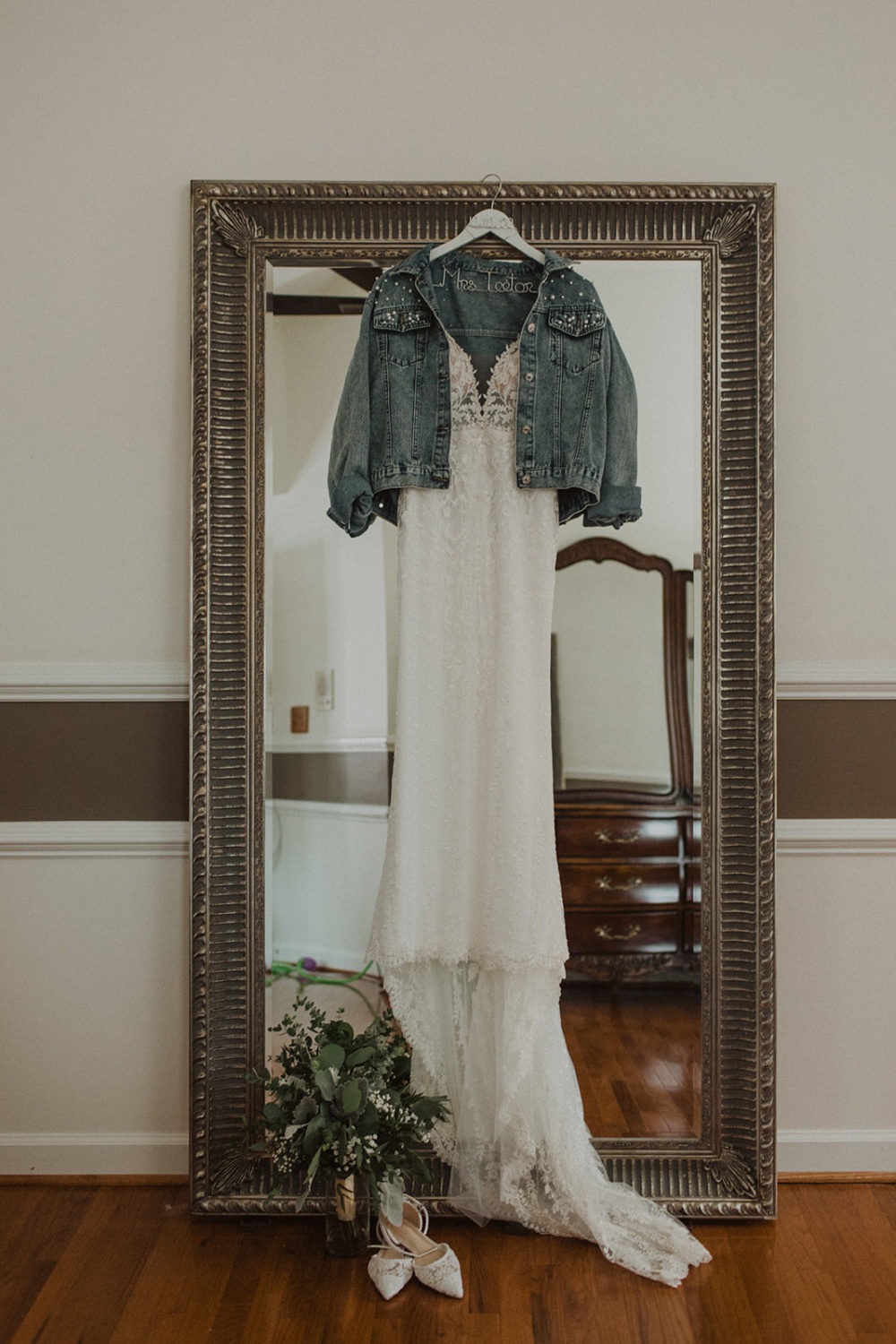 wedding dress hangs on mirror with accessories