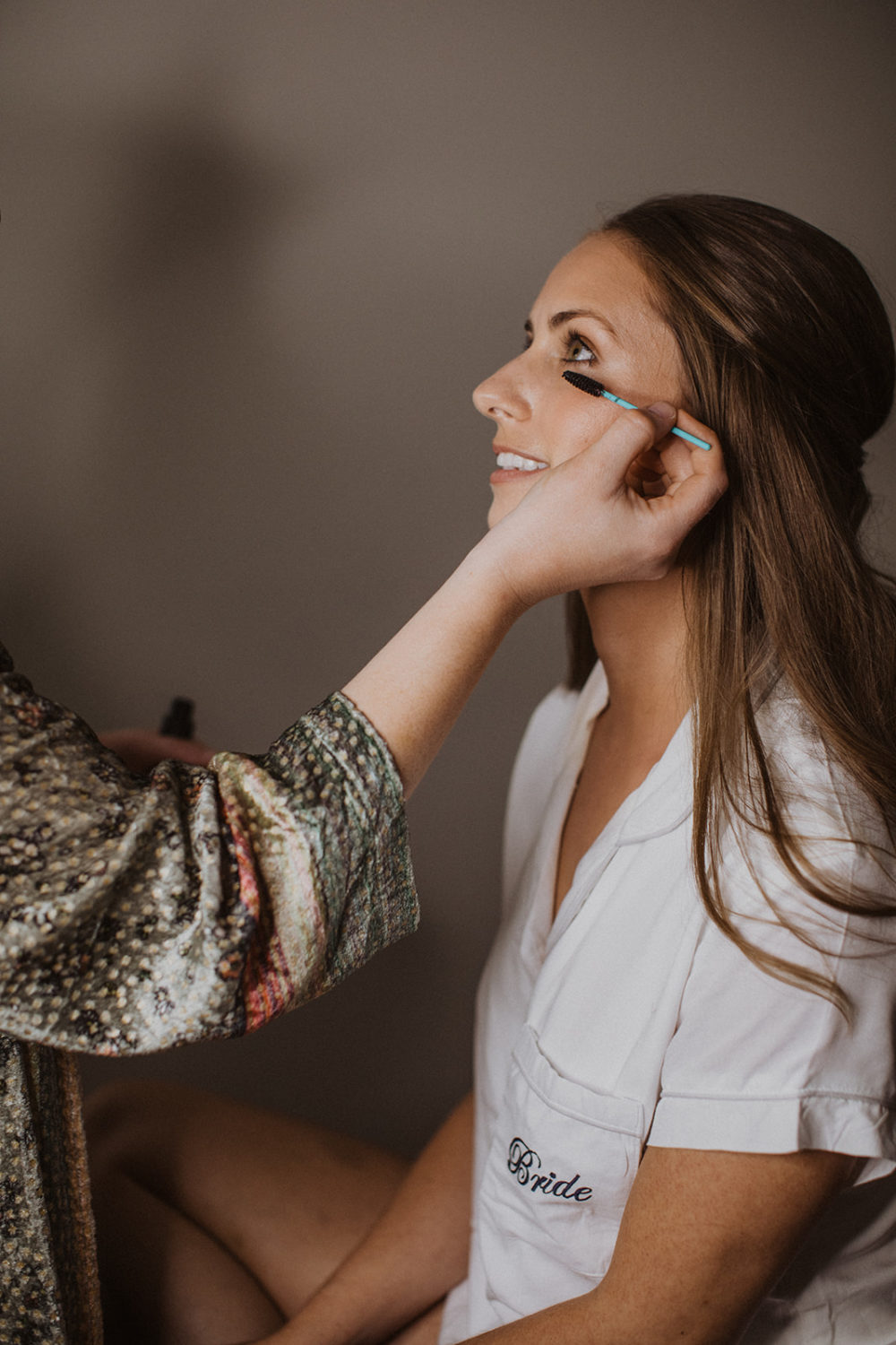 Bride gets makeup done during wedding day getting ready