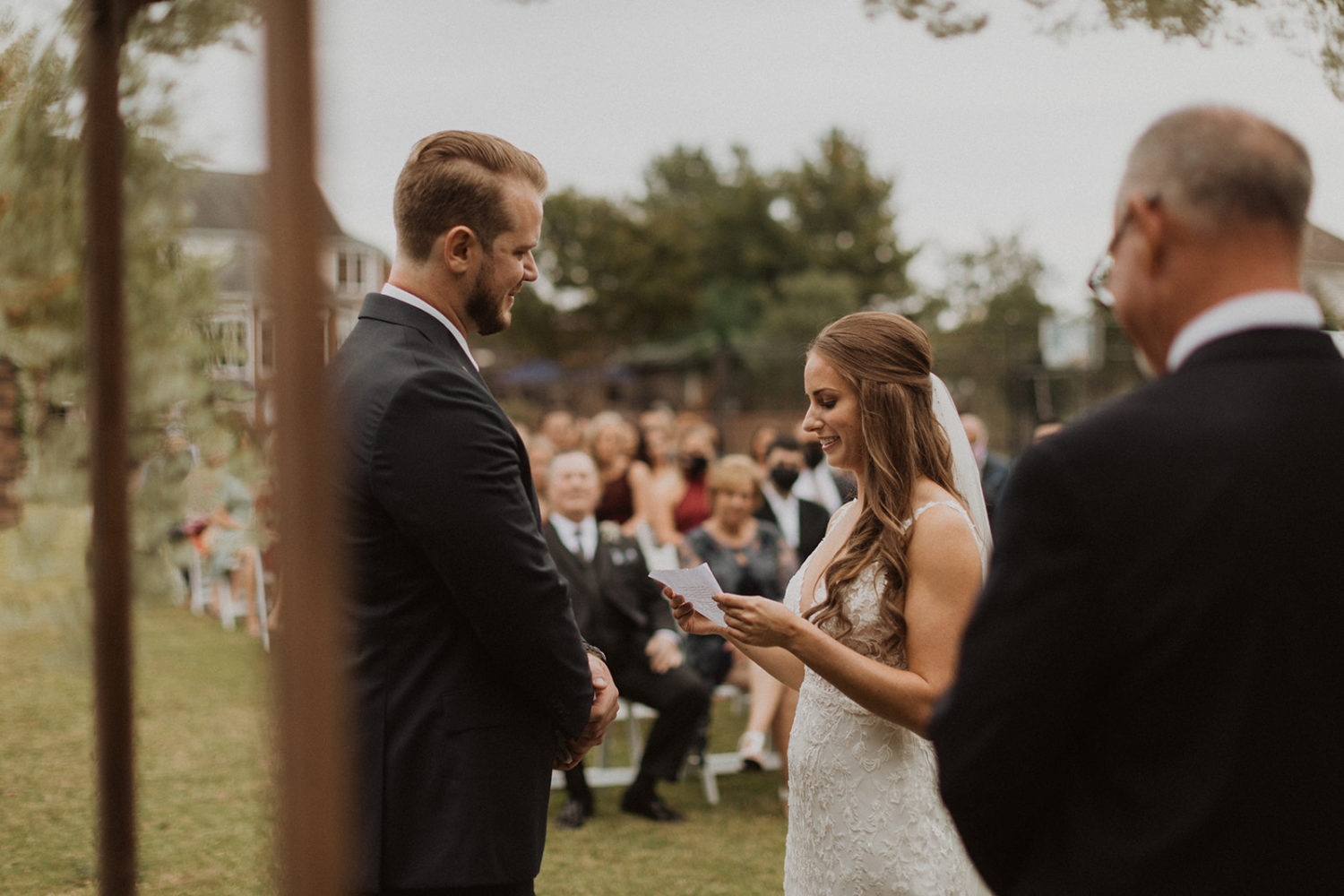 Bride and groom exchange vows during backyard wedding ceremony