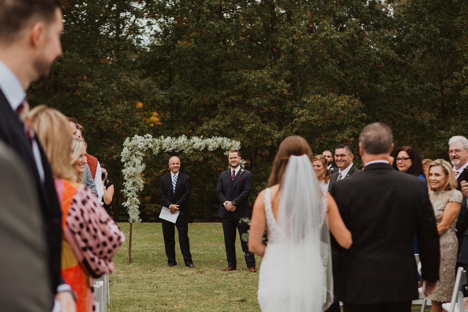 Bride walks towards groom while holding dad's arm