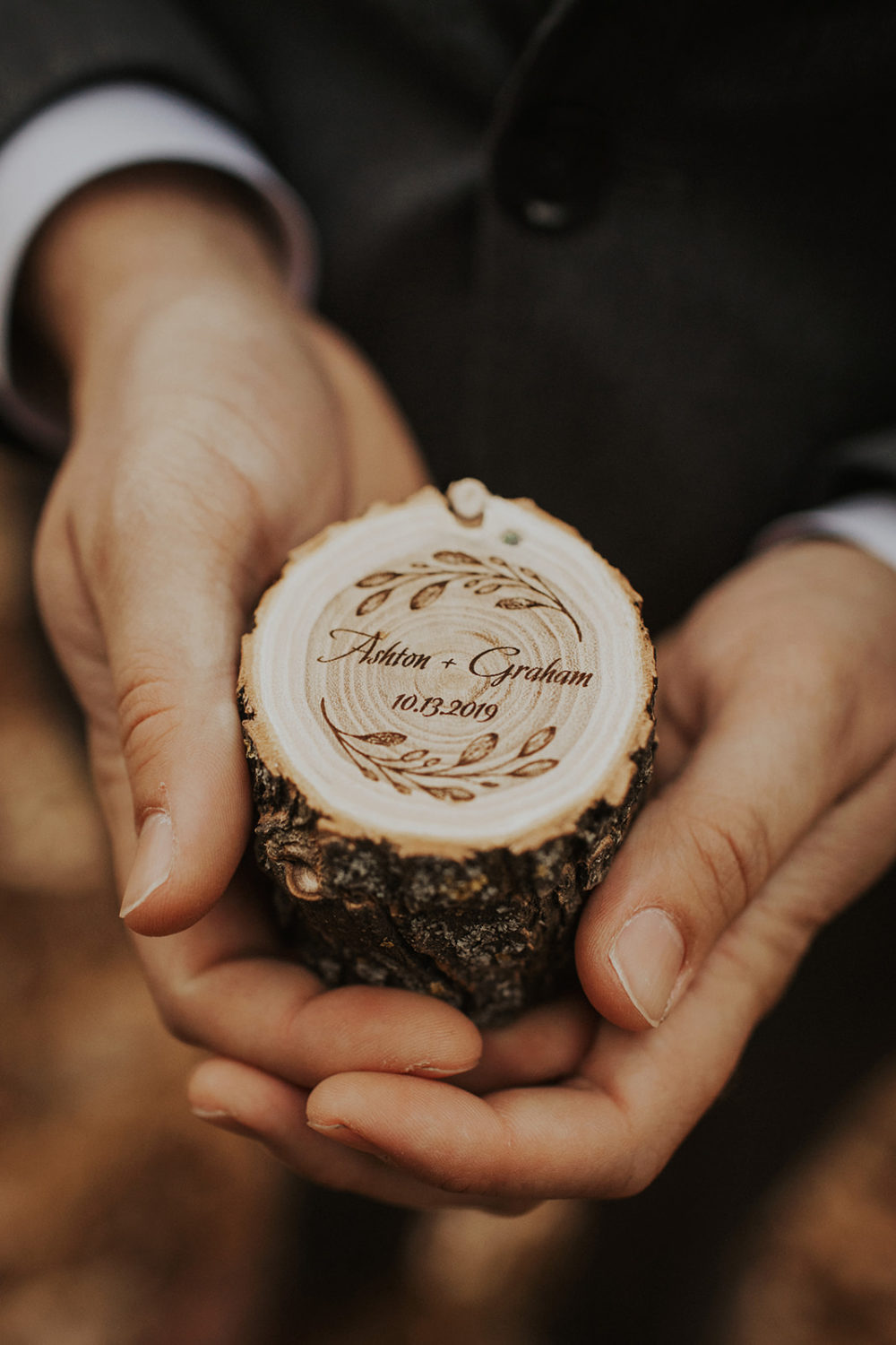 Groom holds personalized wooden wedding rings box