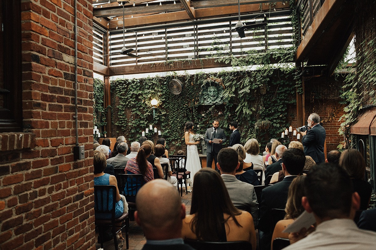 Couple exchanges vows in front of ivy-covered wall