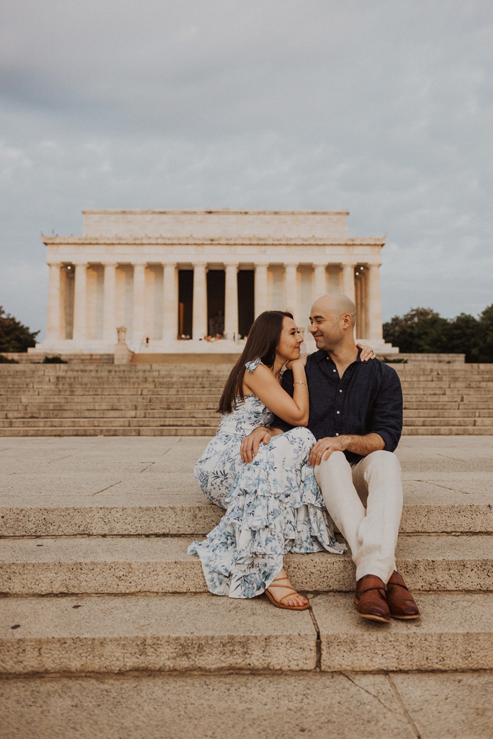 Couple sits on steps of Lincoln Memorial at sunrise