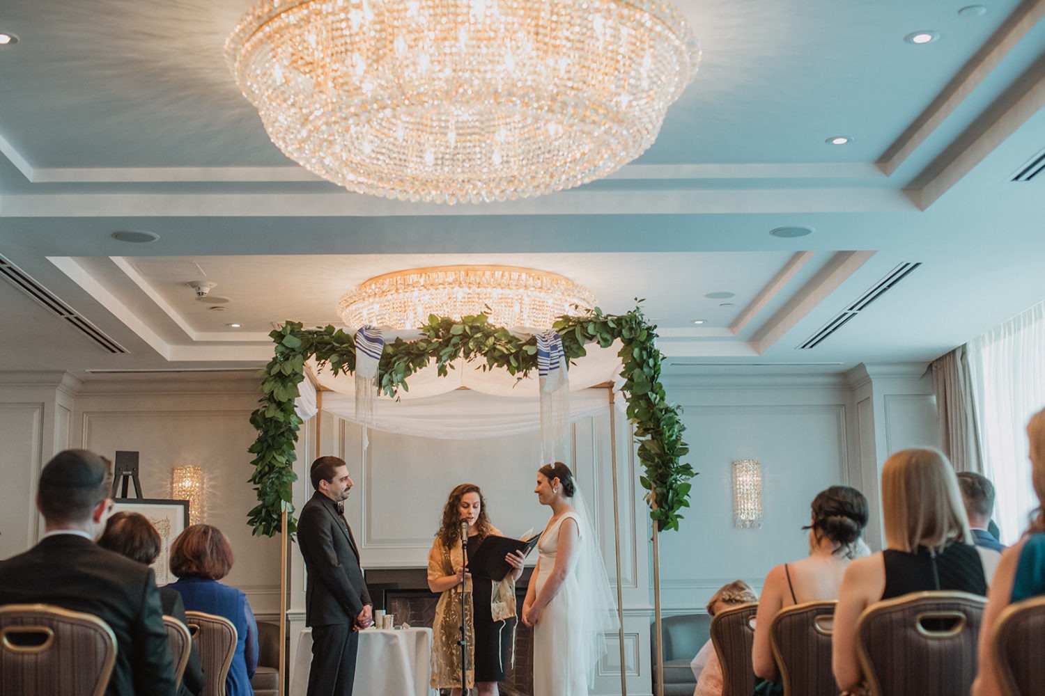 Couple exchanges vows under canopy in hotel ceremony