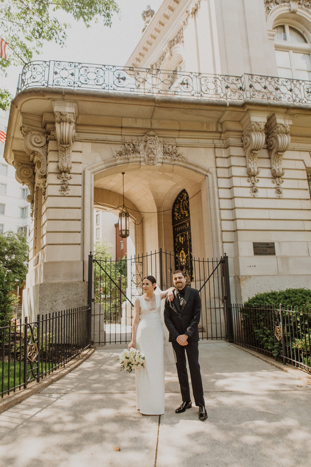 Couple stands outside gate of historic building in Dupont Circle