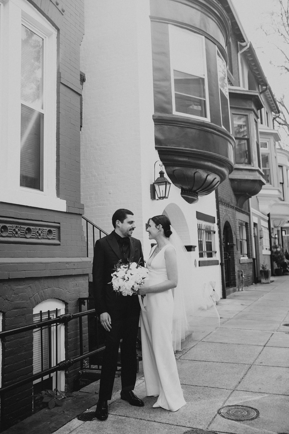 Couple stands on sidewalk by row house in Dupont Circle