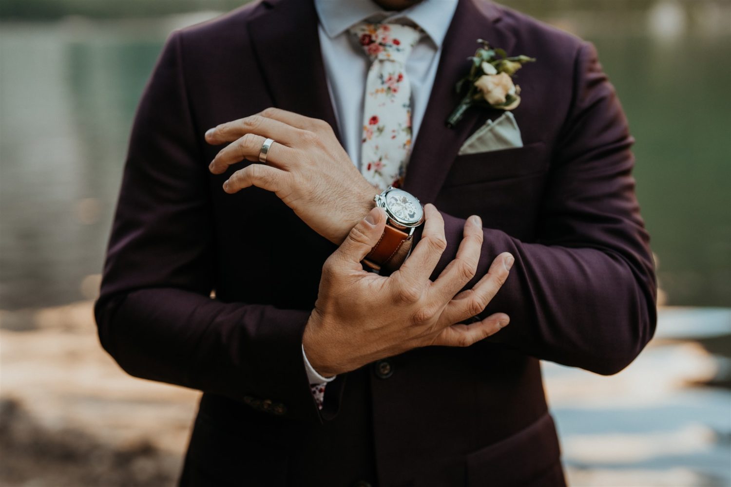 Groom puts on accessories at Dolomites lakeside elopement