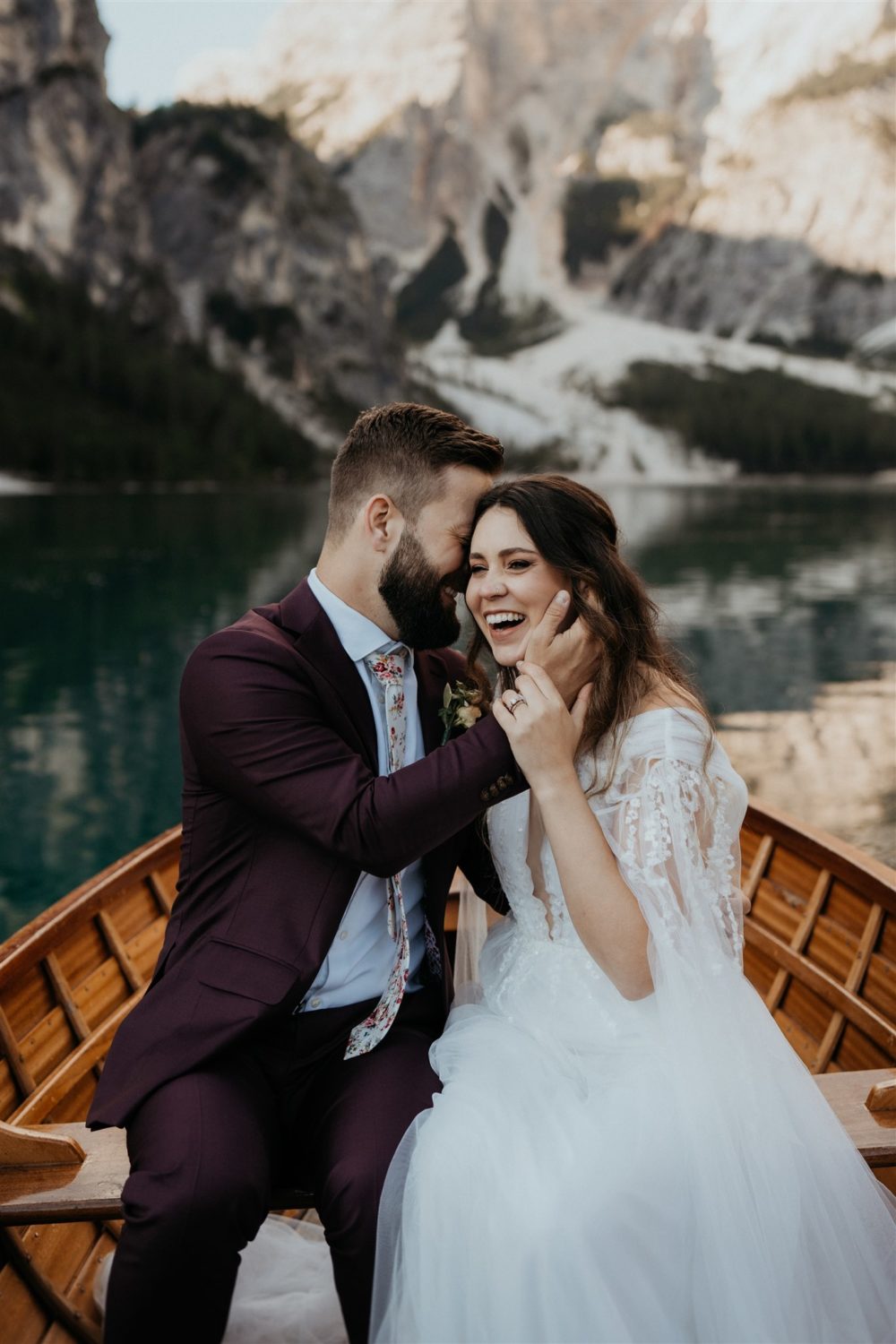 Couple embraces in boat on lake in Dolomites