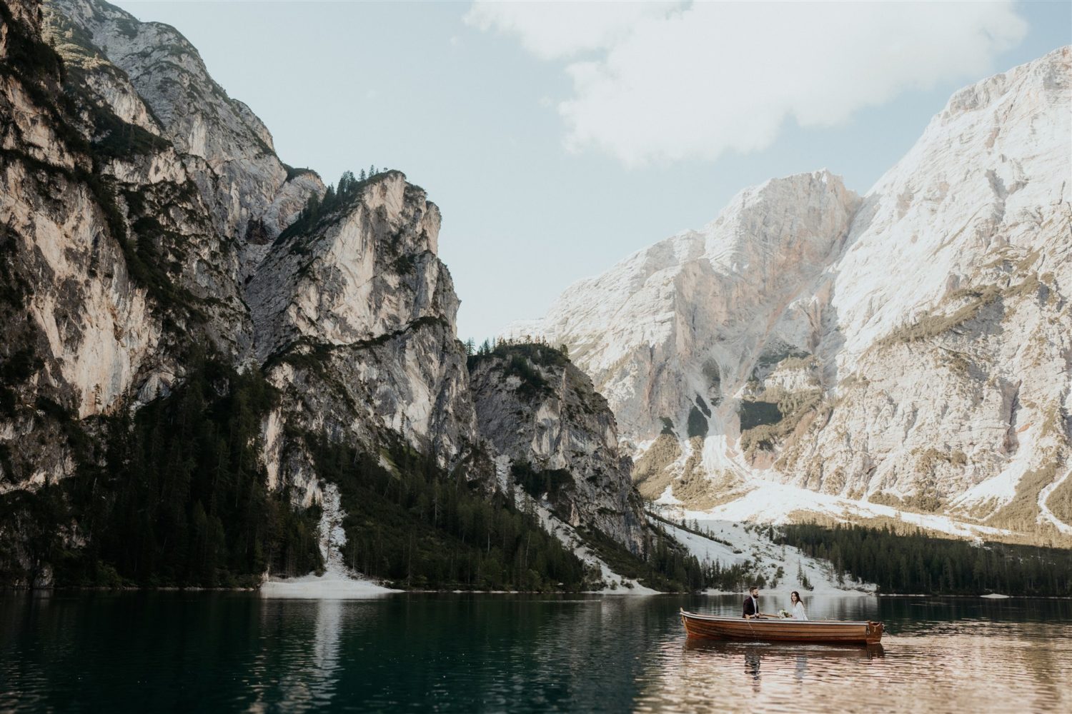 Couple rows boat in lake by dolomites 