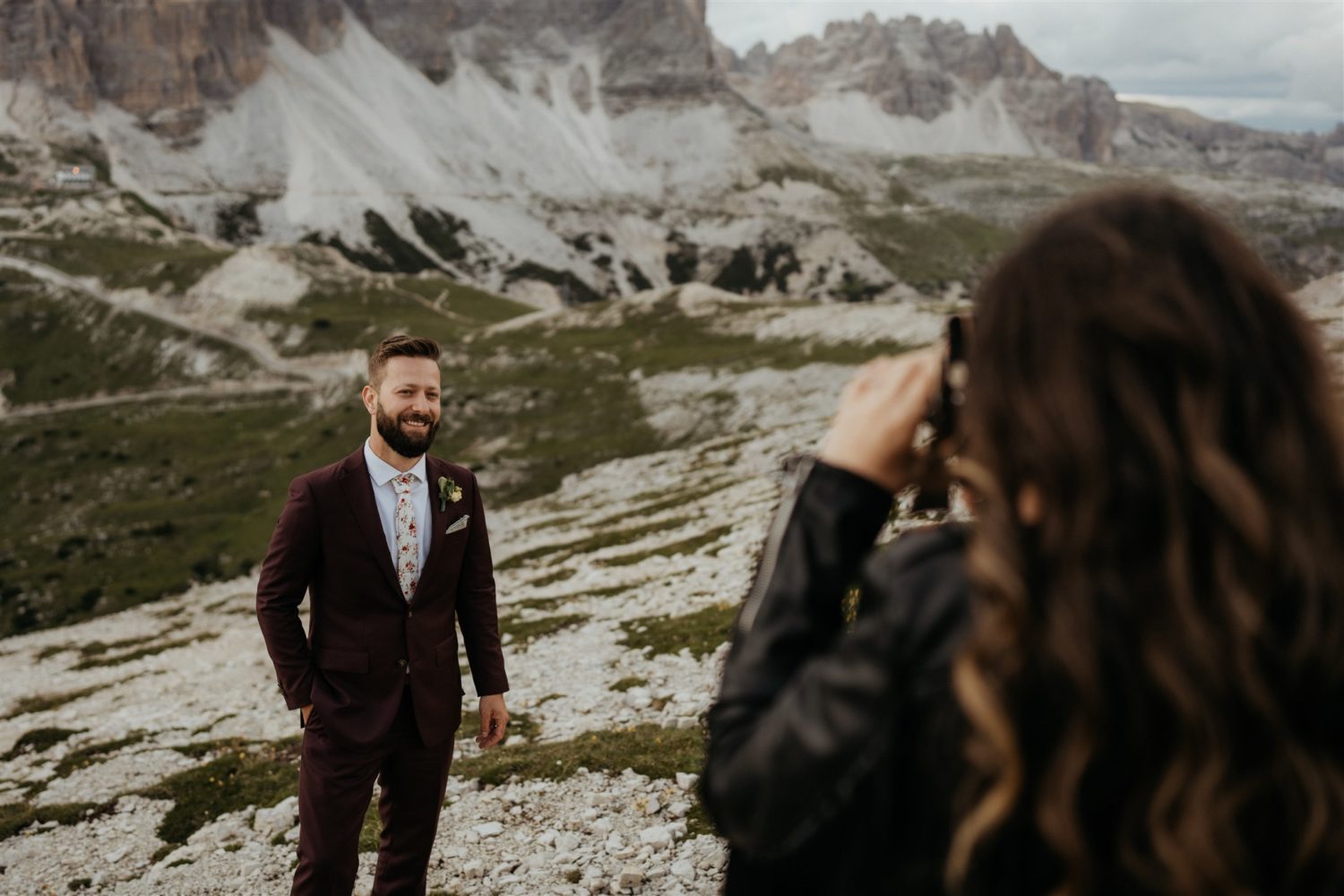 Destination wedding photographer takes photos of groom while in wedding dress