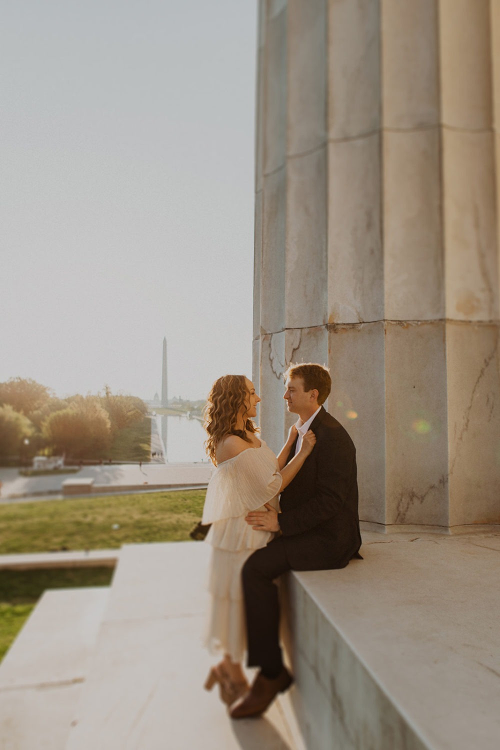 Couple embraces on steps of Lincoln Memorial at sunrise engagement session