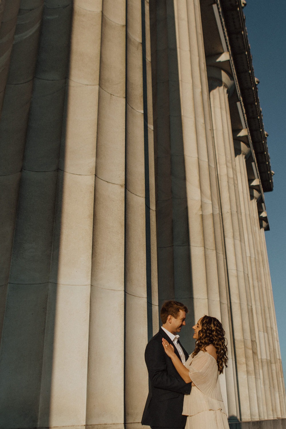 Couple captured by DC engagement photographer beside Lincoln Memorial columns
