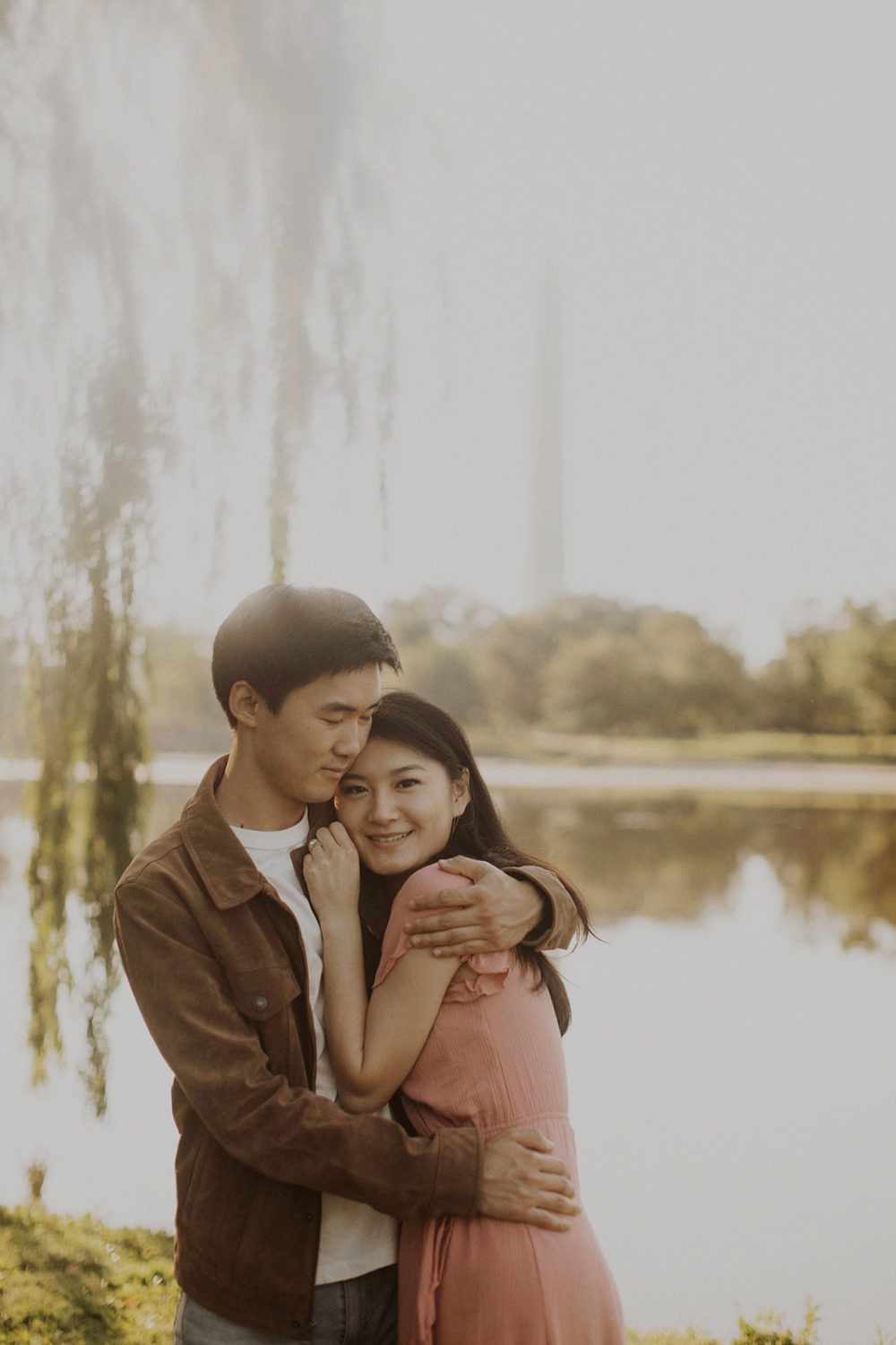Couple embraces by reflecting pool at sunrise engagement session