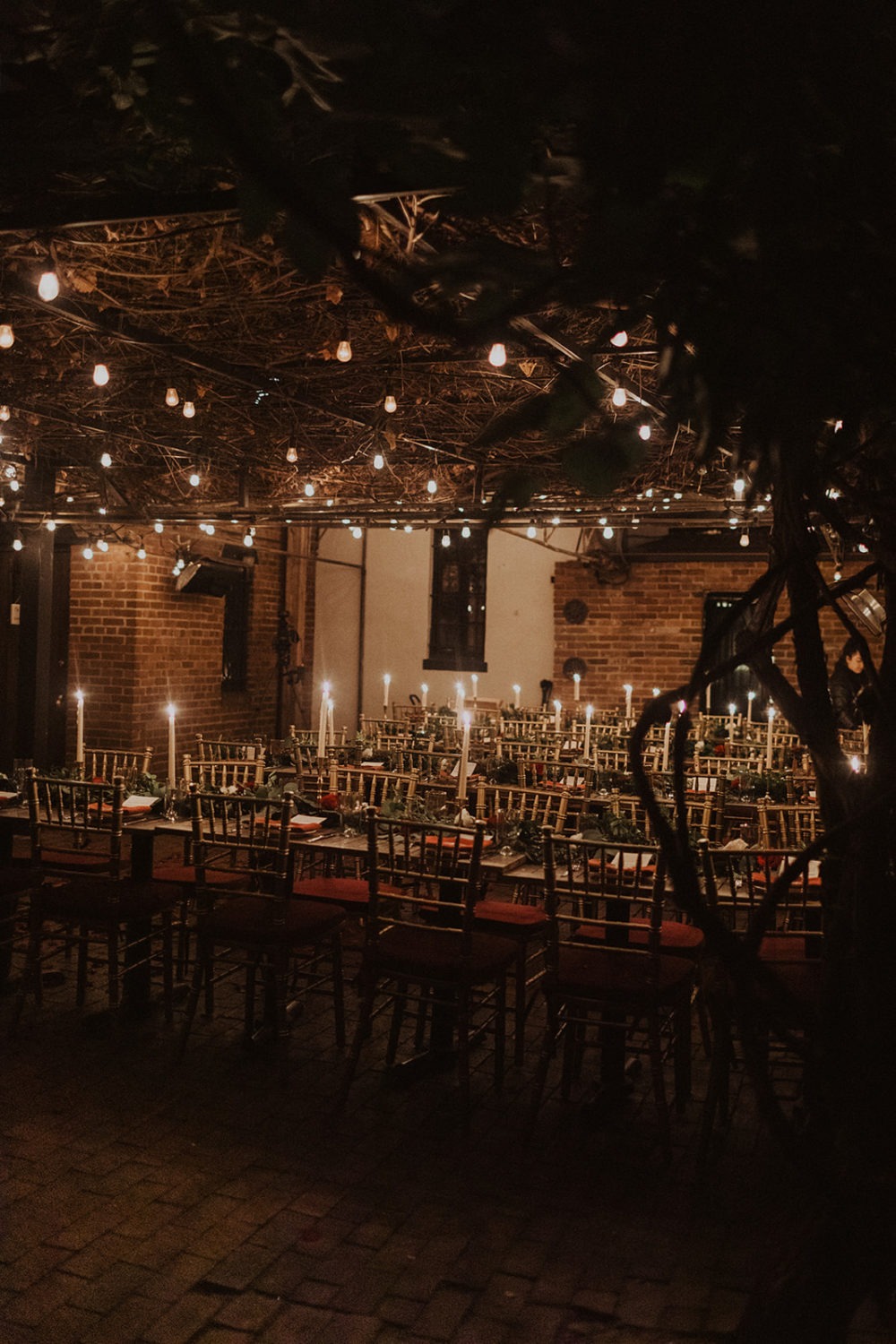 Twinkle lights and candles decorate Iron Gate restaurant outdoor reception 