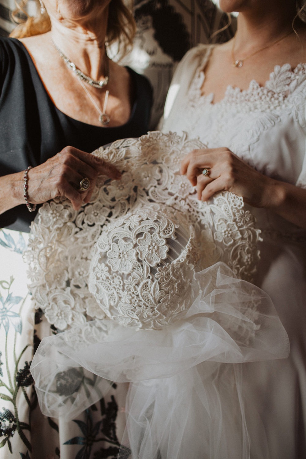 Bride and mom hold wedding veil together