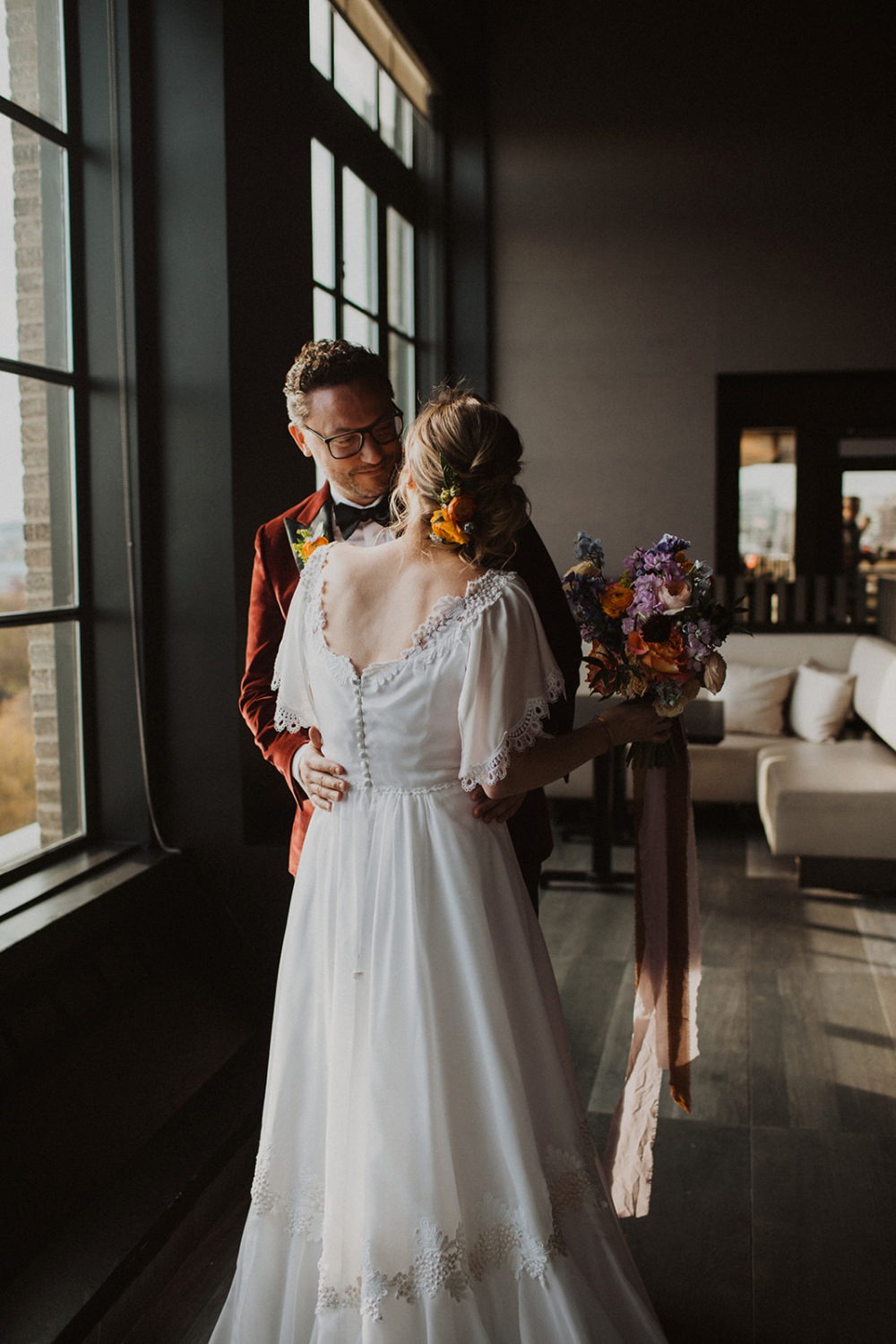 Groom embraces bride during first look