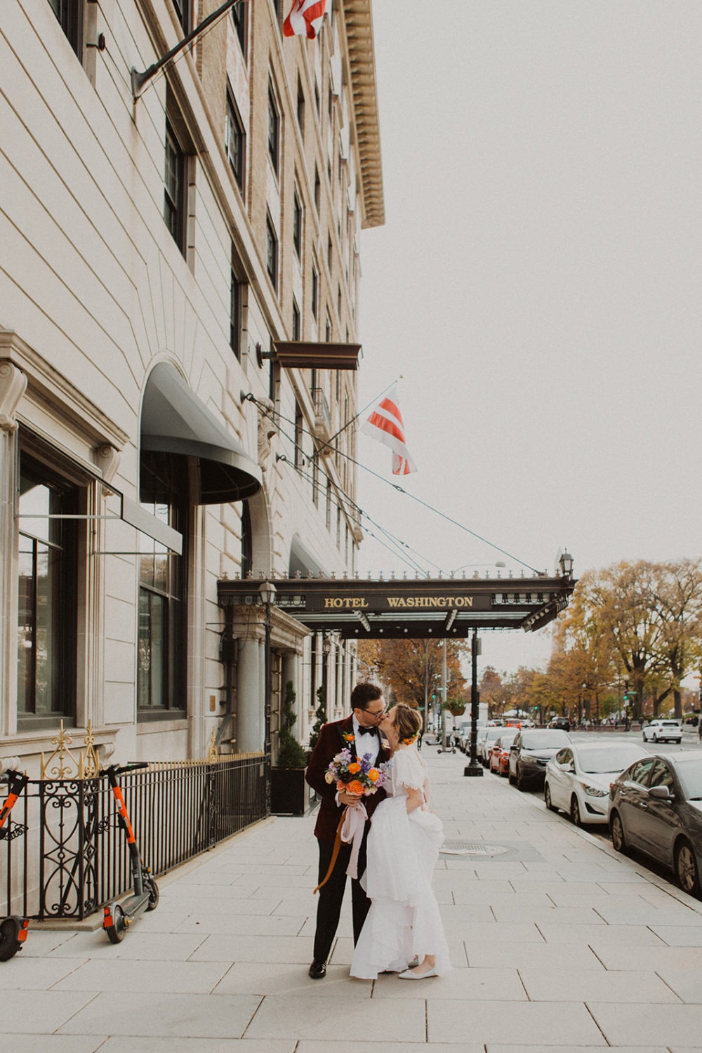 Couple kisses under  Hotel Washington, Washington DC sign