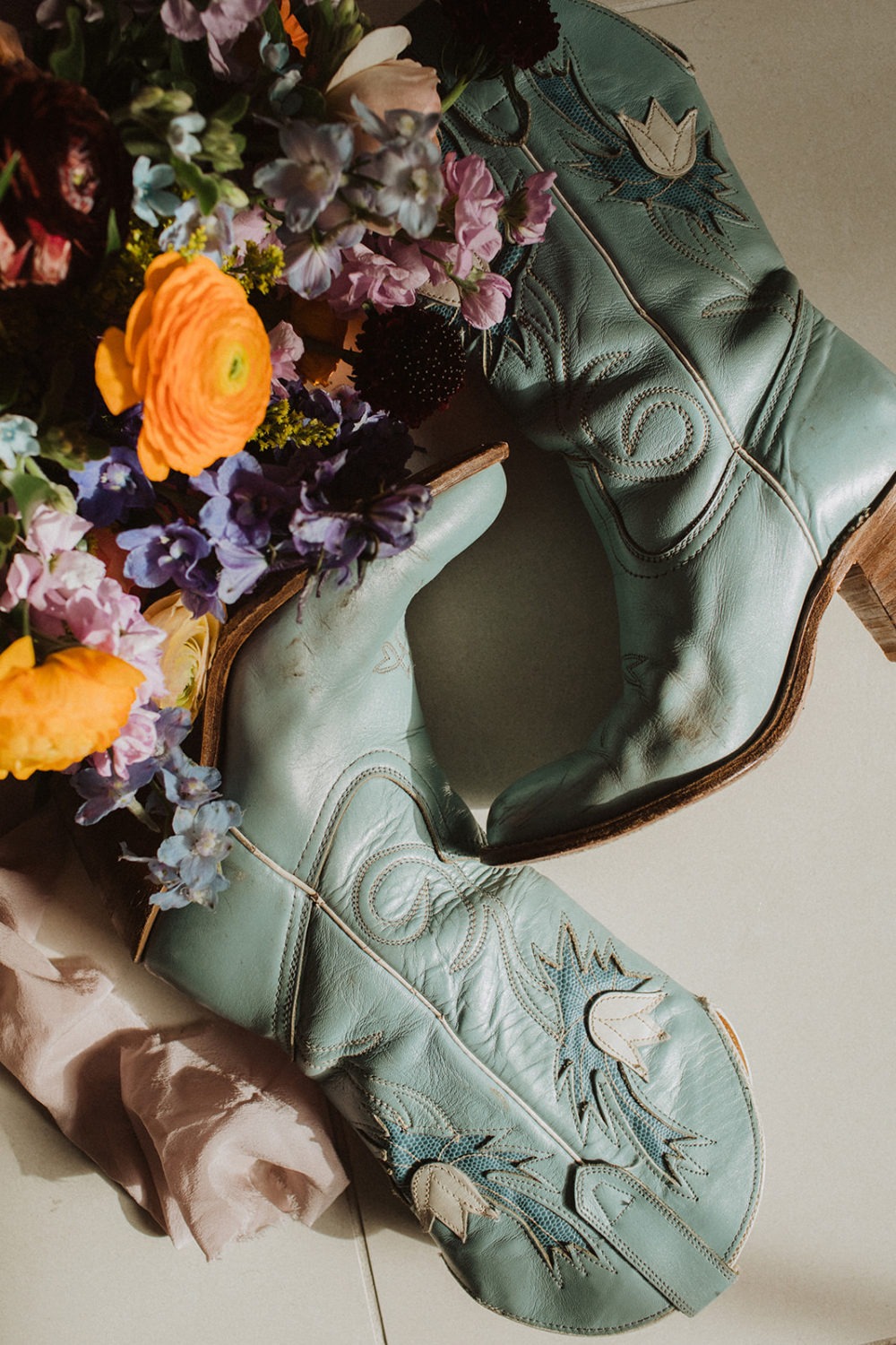 wedding flowers and blue cowgirl boots in sunlight
