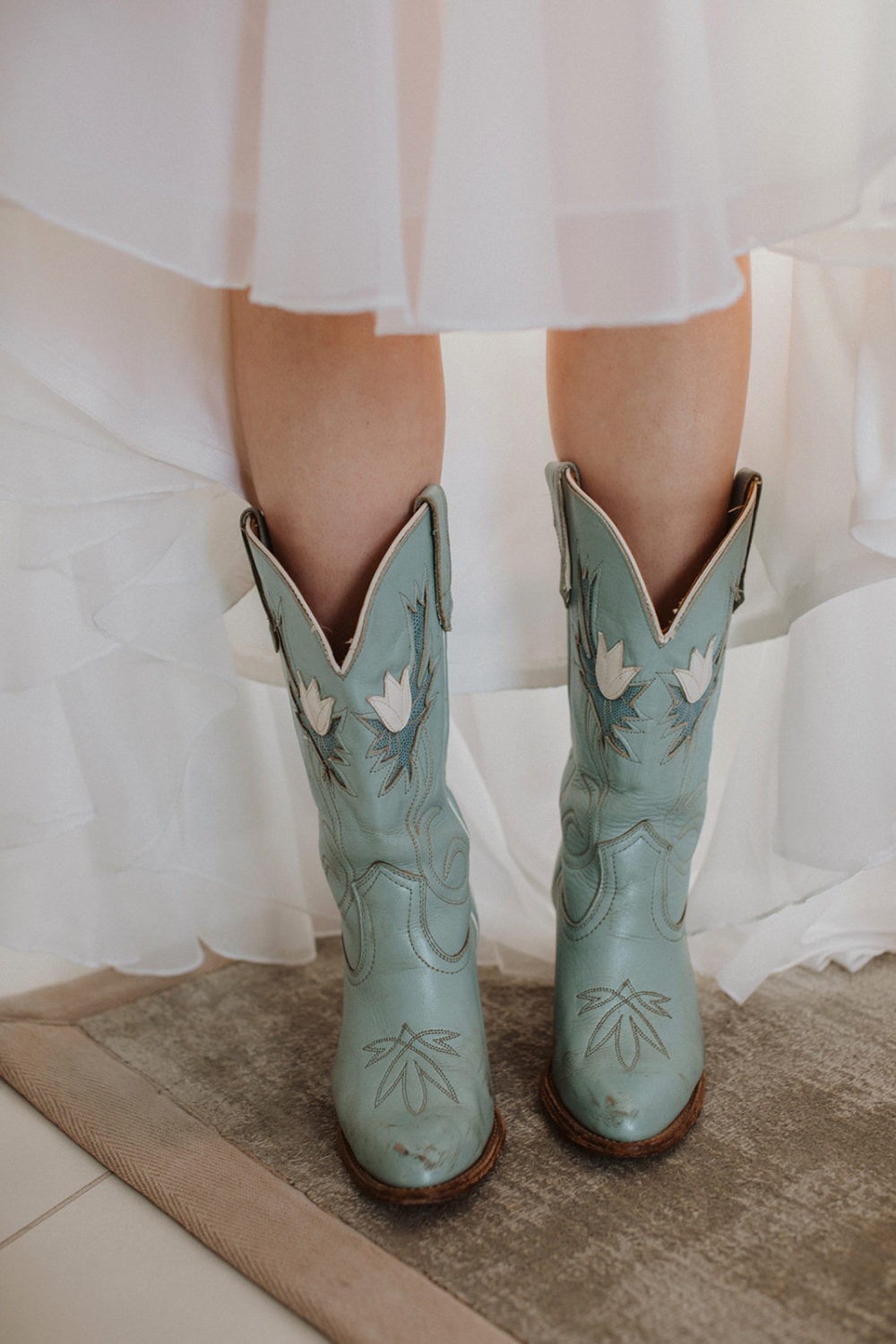 Blue cowgirl boots on bride under wedding dress