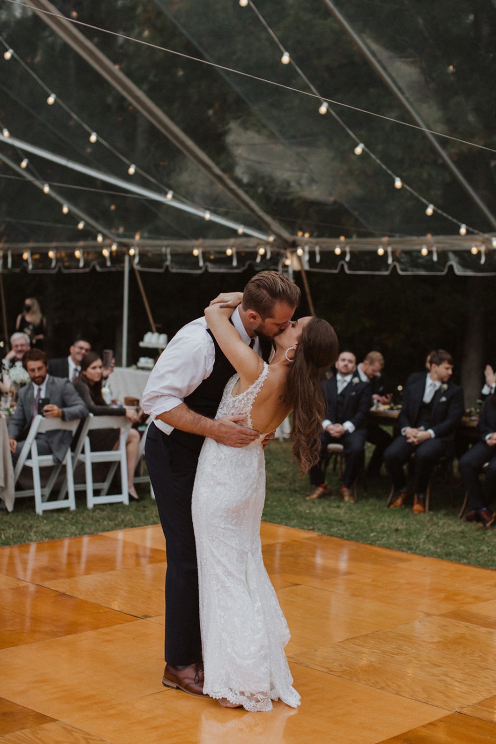 Couple kisses on dance floor at tented wedding