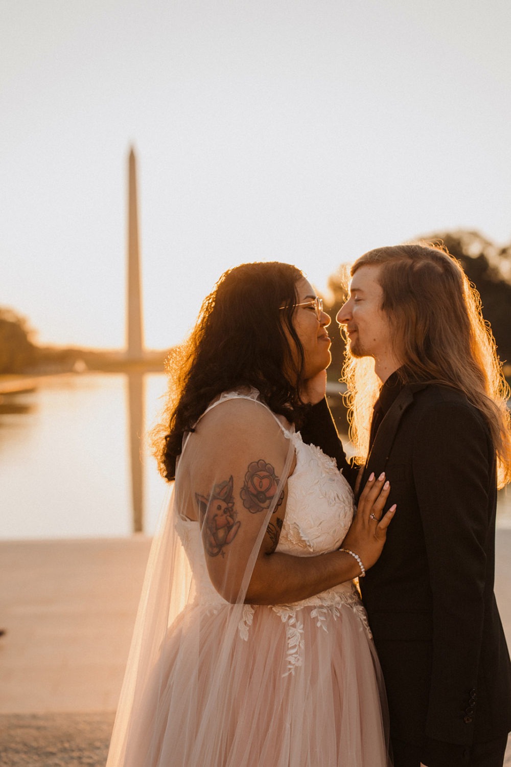 Couple kisses at sunset beside Reflecting Pool 