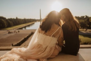 Couple sits on steps at Lincoln Memorial sunset elopement