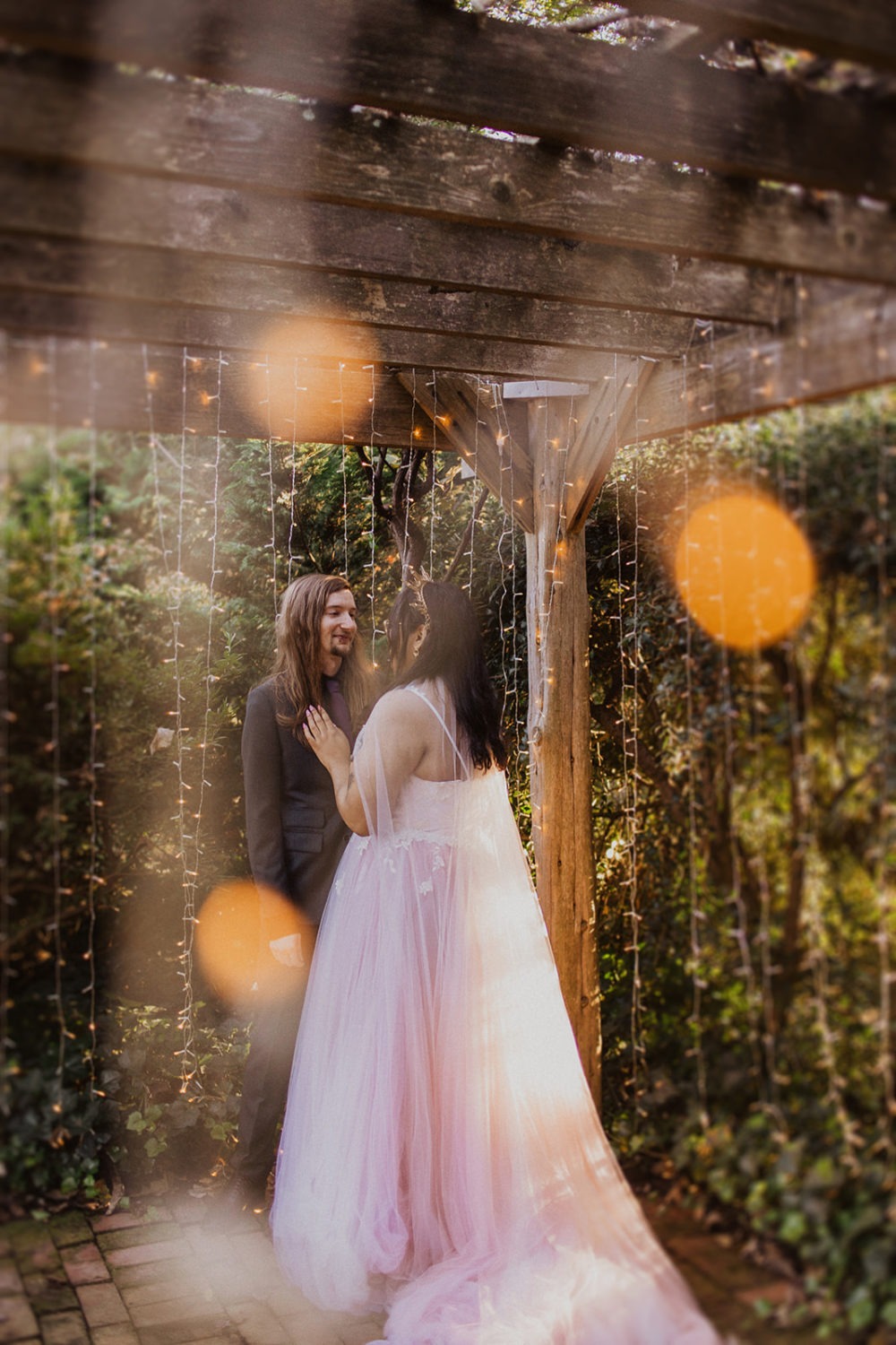 Couple embraces under twinkle lights at DC garden wedding