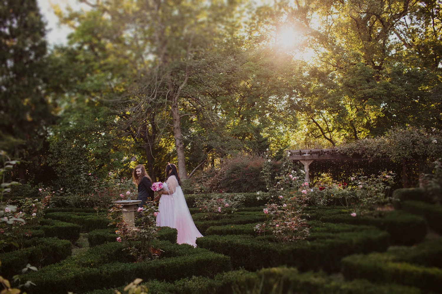 Couple walks through garden at DC sunset wedding