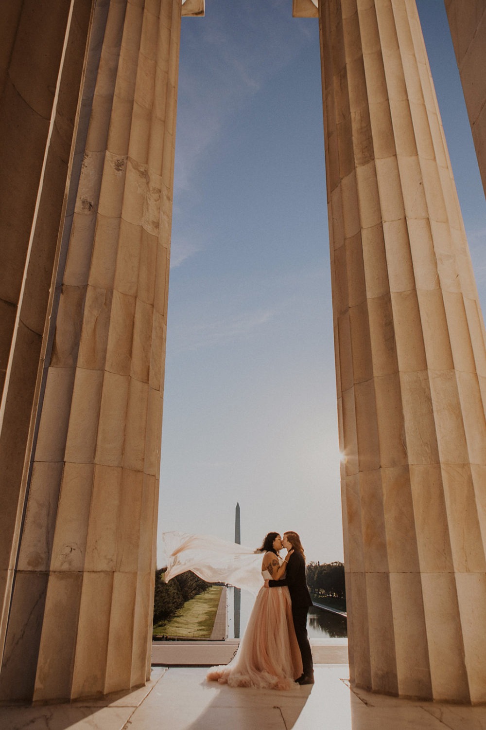 Couple kisses under columns at Lincoln Memorial