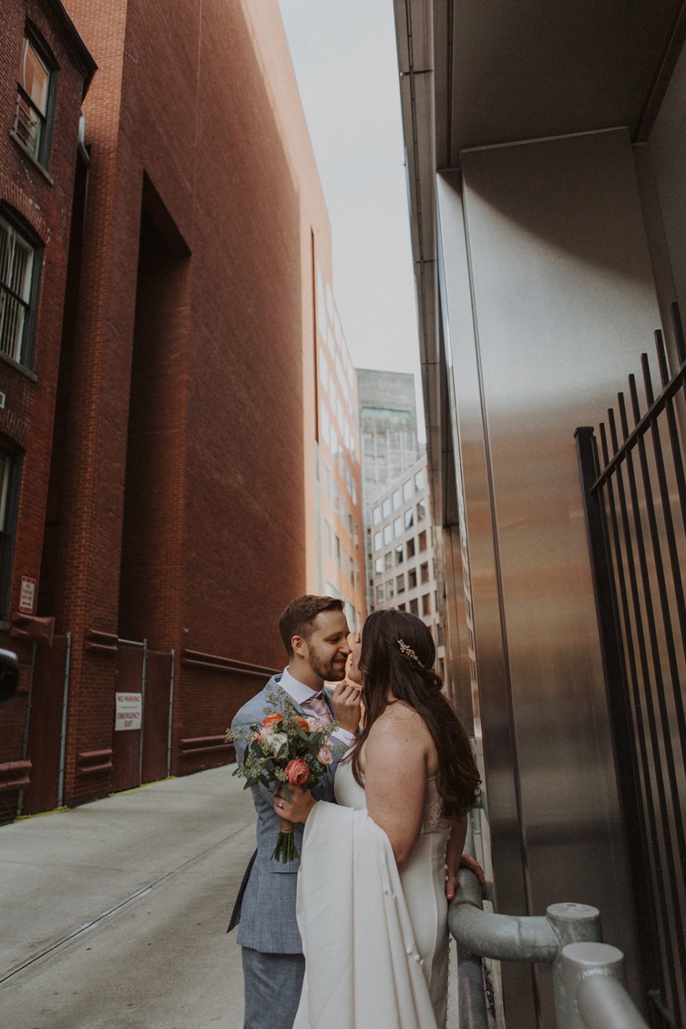 Couple embraces holding wedding bouquet on DC street